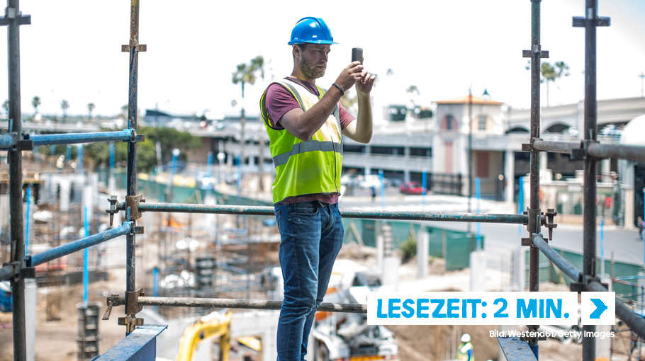 Bauarbeiter auf der Baustelle fotografiert mit dem Smartphone