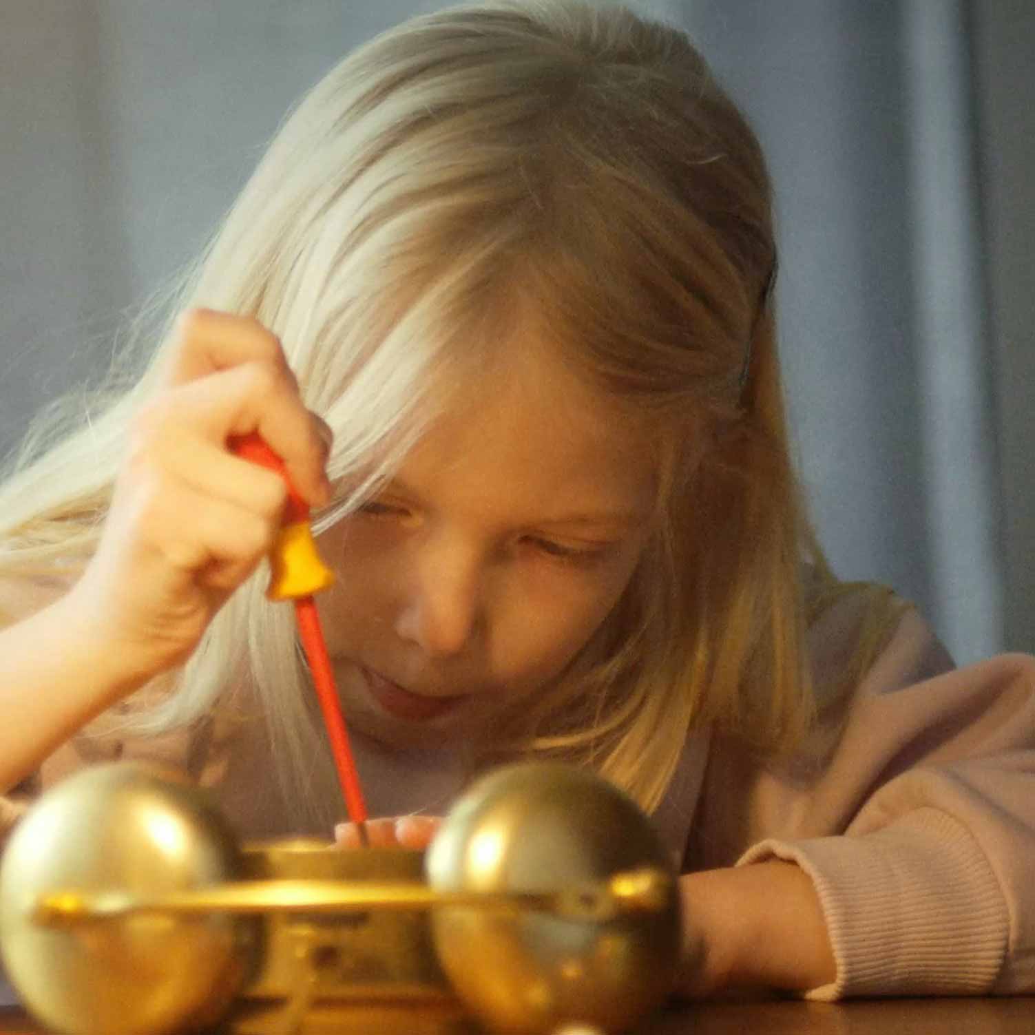 Kind arbeitet mit Schraubenzieher an Uhr