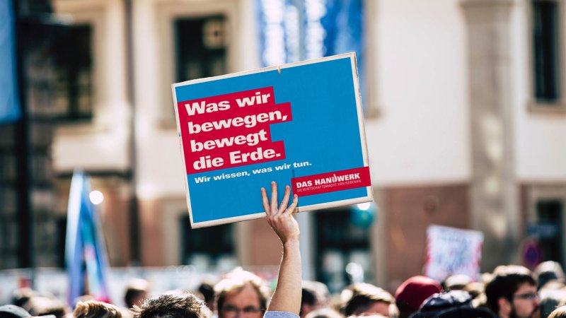 Schild wird in Demo hochgehalten