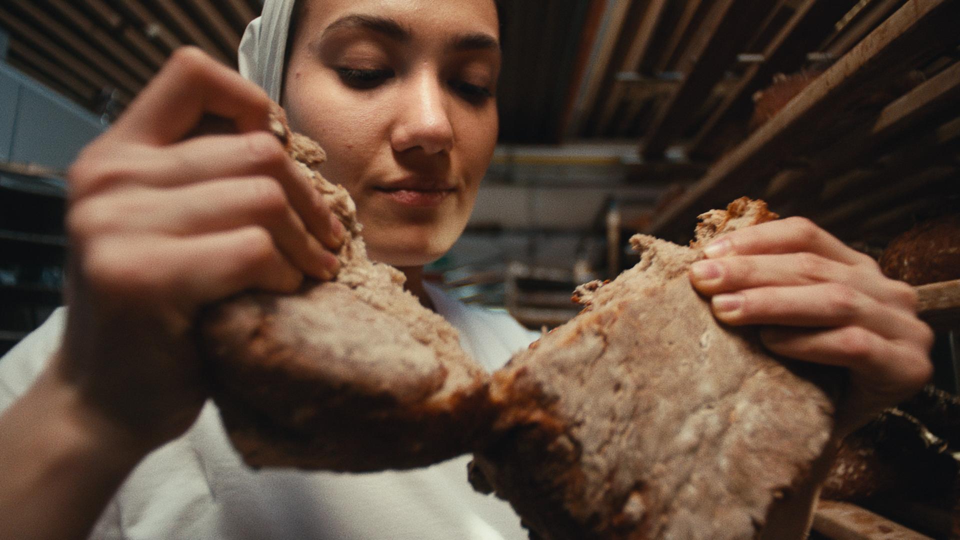 Bäckerin Malika riecht an frisch gebackenem Brot