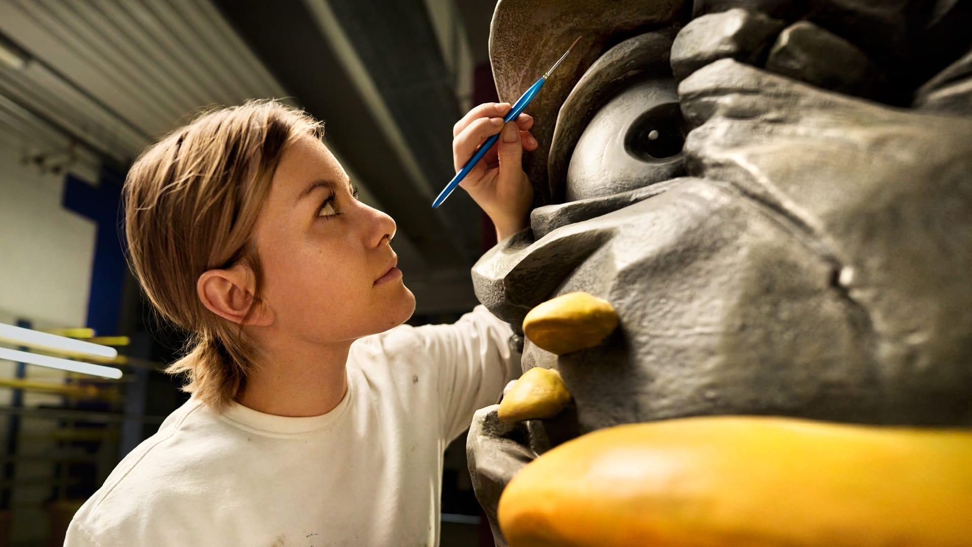 Eine Malerin bemalt einen Troll