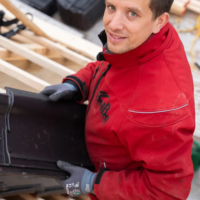 Mann in roter Jacke lacht in die Kamera