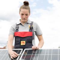 Handwerkerin baut Photovoltaikanlage auf