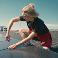 Handwerkerin baut Photovoltaikanlage auf