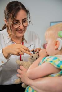 Frau mit Brille bei Untersuchung mit Kind